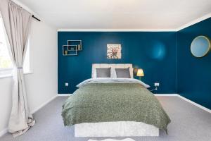 a blue bedroom with a large bed in it at Inglewood Hub in London