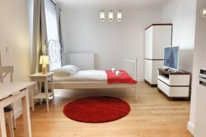 um pequeno quarto com uma cama e um tapete vermelho em Résidence Capitale - City Center em Bruxelas