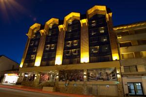 un edificio alto con luces en el costado. en Lagos Andinos, en San Carlos de Bariloche