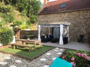 a patio with a wooden table and a bench at Maison de Charme l Etoile in Saint-Vincent-de-Cosse