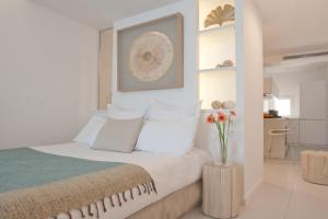 Studio cozy sur la Marina de Bonifacio في بونيفاسيو: غرفة نوم مع سرير مع إناء من الزهور