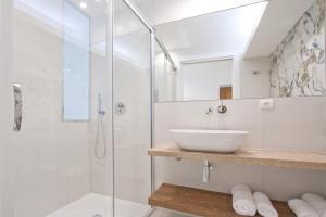 uma casa de banho com uma cabina de duche em vidro e um lavatório. em Studio cozy sur la Marina de Bonifacio em Bonifacio