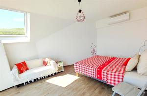 a bedroom with a bed and a couch and a window at Domaine BOHN Red Winehouse in Reichsfeld