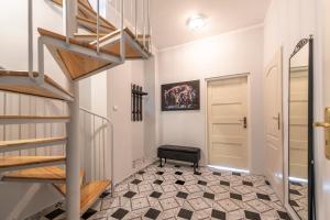 un pasillo con escalera y una planta con suelo a cuadros en Apartament Boheme, en Lądek-Zdrój