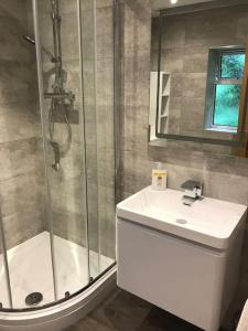 a bathroom with a shower and a toilet and a sink at Beautiful cosy rural retreat with parking! in Winford