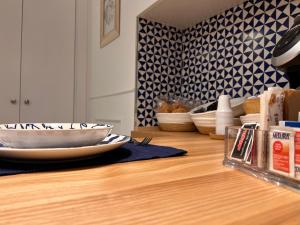 une table en bois avec des assiettes et des bols au-dessus dans l'établissement St. Vincent Apartment, à Castellammare di Stabia 90 autres photos