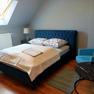 sypialnia z niebieskim łóżkiem i niebieskim krzesłem w obiekcie Willa Różana w mieście Wola Kalinowska