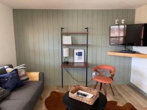 a living room with a couch and a red chair at Pinedale Cozy Cabins in Pinedale