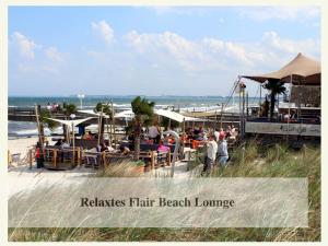 a group of people sitting at a beach restaurant at Meertraum Premium Wohnung mit 3 Zimmern, 250m zum Strand in Scharbeutz