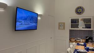 un téléviseur à écran plat accroché au mur dans l'établissement St. Vincent Apartment, à Castellammare di Stabia