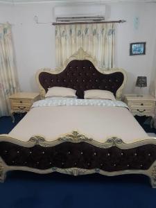 um quarto com uma cama grande e uma grande cabeceira. em Carlcyn Homestay em Gaborone