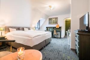 a hotel room with a large bed and a desk at BB Landhotel Hütter in Meschede