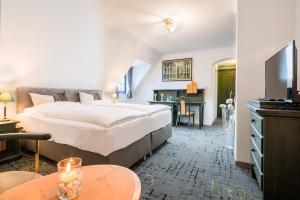メシェデにあるBB Landhotel Hütterの大きなベッドとデスクが備わるホテルルームです。