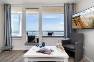 a living room with a desk and a chair and a window at Wattenblick in List