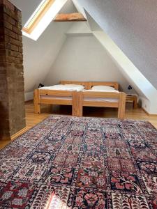 1 dormitorio con cama y alfombra en el ático en Ferienhaus Traminer im Weinberg, en Freyburg