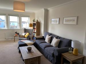 a living room with a blue couch and a table at The Lookout in Cellardyke