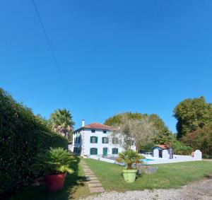 a white house with plants in front of it at Gite Moulin Urketa in Ayherre