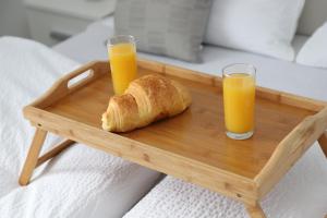 a tray with two glasses of orange juice and a croissant at Apartman Normanci near Bizovac thermal spa in Normanci