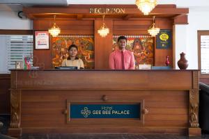 a man and a woman standing behind a bar at Gee Bee Palace in Angamali