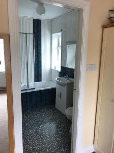 a bathroom with a tub and a toilet and a sink at Kielty's of Kerry Bed and Breakfast in Waterville