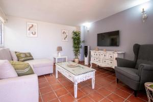 ein Wohnzimmer mit einem Sofa und einem Tisch in der Unterkunft LOR PINTADA Apartment in Nerja