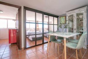 Zimmer mit einem Tisch und Stühlen sowie einem Schlafzimmer in der Unterkunft LOR PINTADA Apartment in Nerja
