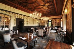 jadalnia ze stołami i krzesłami oraz żyrandolem w obiekcie Thornton Hall Hotel & Spa w mieście Heswall