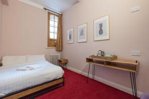 a bedroom with a bed and a wooden table at Palmers Lodge Swiss Cottage in London