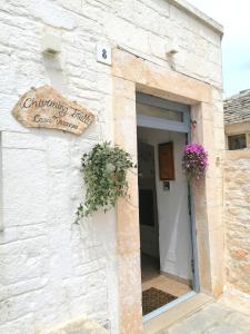 un edificio blanco con un letrero que dice trepar a un pequeño hostal en Charming Trulli en Alberobello