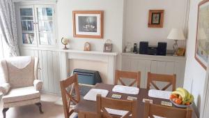 uma sala de jantar com mesa e cadeiras e uma sala com mesa em Mabel Cottage Sheringham em Sheringham