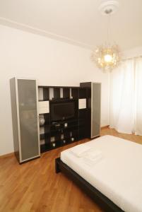 a bedroom with a bed and a flat screen tv at Vatican Sunset Guest House in Rome