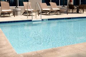 una gran piscina con sillas y mesas en un hotel en Hyatt Place Atlanta / Alpharetta / Windward Parkway, en Alpharetta
