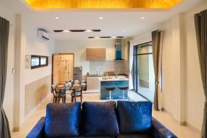 uma sala de estar com um sofá e uma cozinha em Modern Villa Hua Hin 华欣静家之泳池四合院 em Hua Hin