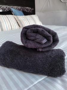 a purple towel sitting on top of a bed at Skywoods.glamping in Molėtai
