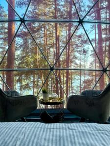 um quarto com uma cama e cadeiras e uma grande janela em Skywoods.glamping em Molėtai