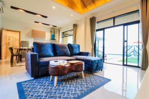 sala de estar con sofá azul y mesa en Modern Villa Hua Hin 华欣静家之泳池四合院 en Hua Hin