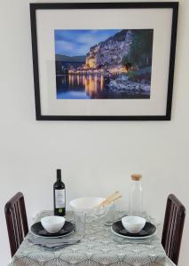 stół z dwoma talerzami i butelką wina w obiekcie LES STUDIOS DE SARLAT w mieście Sarlat-la-Canéda