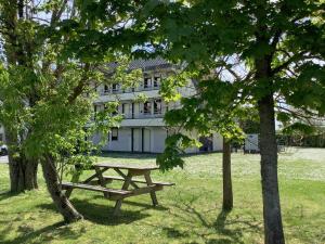 a picnic table in front of a building with trees at Première Classe Chateauroux - Saint Maur in Saint-Maur