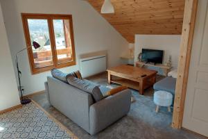 ein Wohnzimmer mit einem Sofa und einem Tisch in der Unterkunft Apartment Croix Carail - Completely renovated in Roubion in Névache