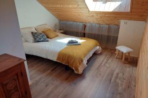 a bedroom with a bed and wooden floors and a skylight at Apartment Croix Carail - Completely renovated in Roubion in Névache +3 photos