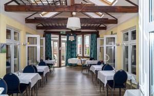 a dining room with white tables and chairs and windows at Trip Inn Kongresshotel Frankfurt-Rodgau in Rodgau