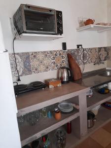 a kitchen with a counter top with a microwave at Cactus y Almacen - Purmamarca in Purmamarca