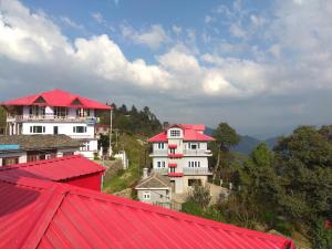 a group of buildings with red roofs on a hill at A.R . Homestay in Shimla