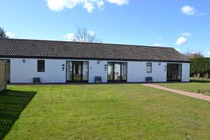 a white building with a large yard in front of it at Number 5 - Lytton Tree Lodge, Reydon, Southwold in Reydon