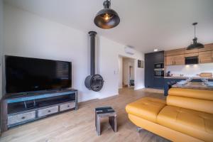 a living room with a couch and a large flat screen tv at Holiday House U Hájenky 5L Lipno Home in Lipno nad Vltavou +19 photos