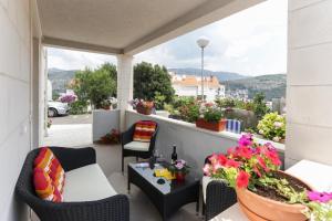 a balcony with a table and chairs and flowers at Apartments Pojko in Dubrovnik