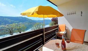 a table with a yellow umbrella and a view of a river at MAREN Seeblick Appartement Haus Hänsel&Gretel am Ossiacher See, Hallenbad, Skiarena Gerlitzen in Stiegl +44 photos