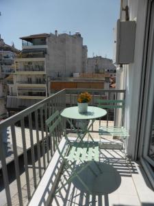 einen Tisch und Stühle auf einem Balkon mit Aussicht in der Unterkunft DREAM HOME in Larisa
