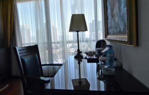 a desk with a lamp and a chair in front of a window at Hotel Monec in Ankara