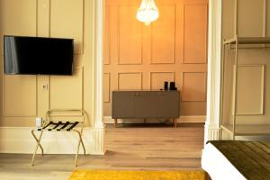 a living room with a tv and a chair at Arte Nova Guesthouse in Covilhã